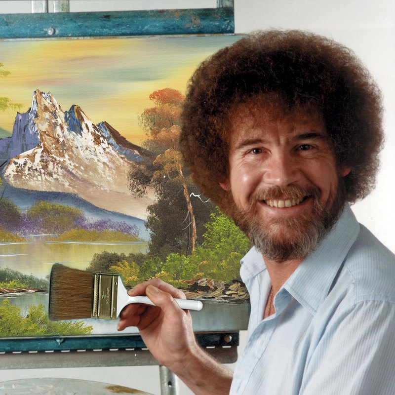 Bob Ross with a brush in front of a mountain landscape