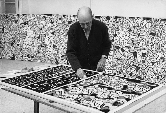Illustration for: Jean Dubuffet in his studio in Vence, 1964, with the oster of the “L'Hourloupe”-exhibition at Palazzo Grassi, Venice, photo: Max Loreau. © Archives Fondation Dubuffet, Paris / © VG Bild-Kunst, Bonn 2025.