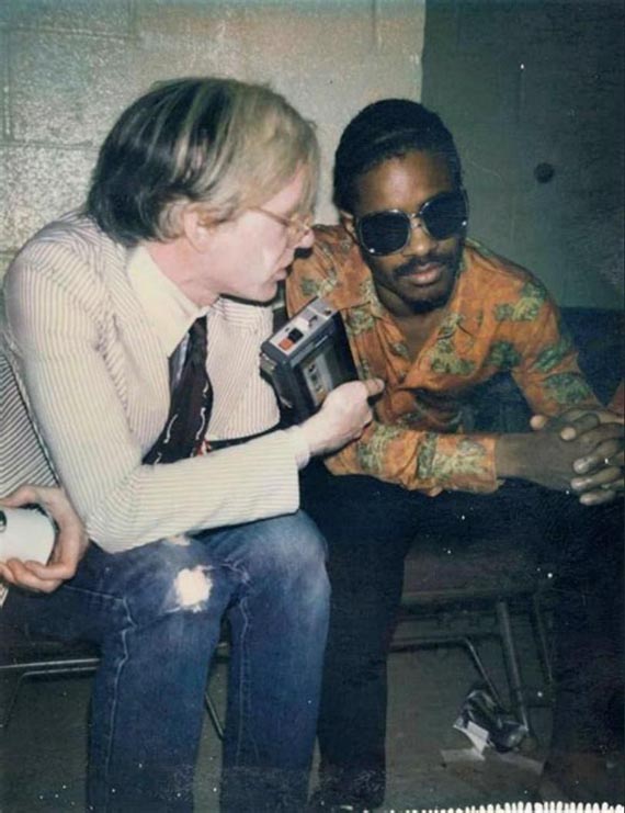 Illustration for: Stevie Wonder and Andy Warhol backstage at a Rolling Stones concert at Madison Square Garden in 1972, Andy Warhol Foundation. © The Andy Warhol Foundation for the Visual Arts